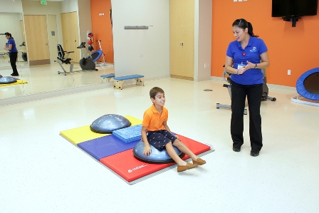 Photo Caption: Carol Monzon, Occupational Therapist and seven-year-old Ronald Lopez during a rehabilitation session at MCH Miramar Outpatient Center